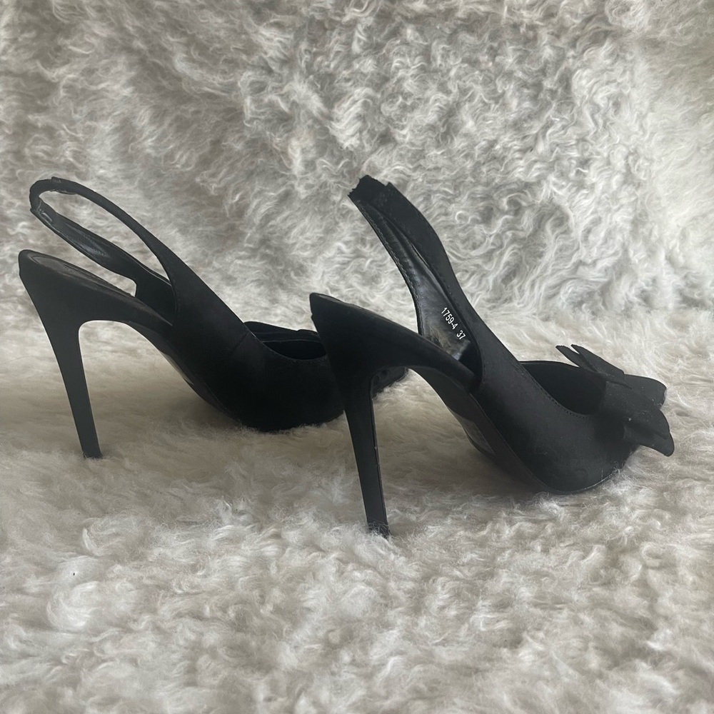 Black pointy toe pumps with bow detail.